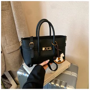 Chic black leather tote bag with stylish top handles, gold hardware, and cute horse charm.