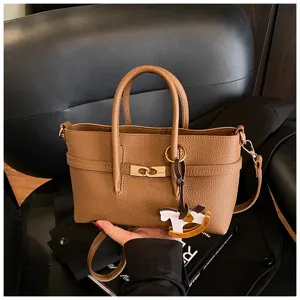 Women's brown leather tote bag with top handles, metal turn lock closure and stylish charm.