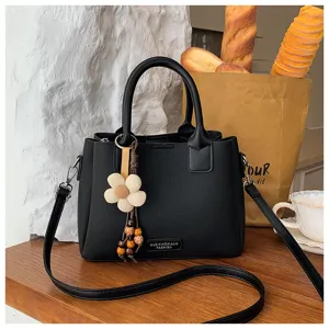 Retro stylish black shoulder bag women crossbody bucket bag with cute flower pendant decor.