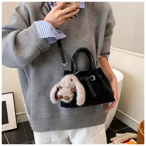 Women stylish black leopard pattern bucket handbag with cute plush bunny charm and shoulder strap.