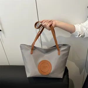 Grey nylon oxford tote bag with brown handles and front patch pocket for women fashion daily use