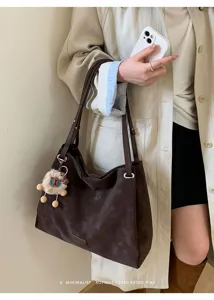 Detail shot of minimalist dark brown matte tote bag with fuzzy plush charm for women daily commute.