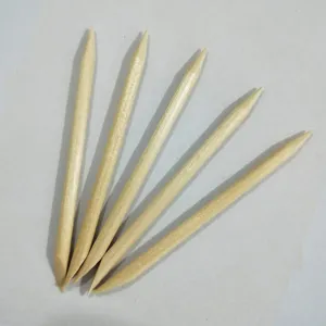 Detailed view of natural wooden cuticle sticks, double-ended nail art tools for cleaning and dotting.