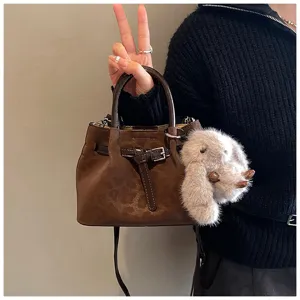 Retro leopard print bucket bag for women with chic belt buckle and cute plush bunny pendant.