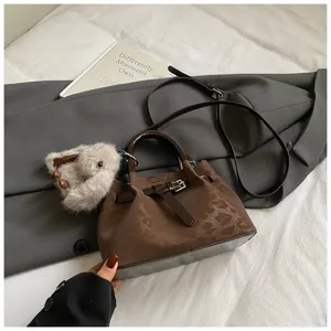 Detailed view of the retro brown bucket bag featuring dark floral pattern and cute bunny charm.