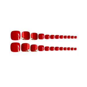 Detail van rode steentjes teennagels met sprankelend kristaldecor op rode kunstnagels.