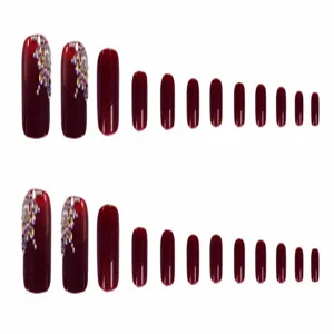 Detail van bordeauxrode kunstteennagels met glanzende afwerking, strass steentjes en parels.