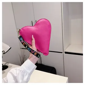Sac pochette coeur en cuir rose avec dragonne love coloree pour la mode ete des femmes.