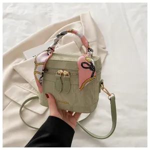 Primer plano detallado del bolso verde elegante con pañuelo de seda estampado en asa.