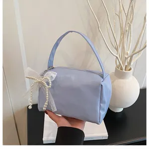 Trousse de maquillage bleu clair avec nœud en perles, sac de rangement voyage portable.