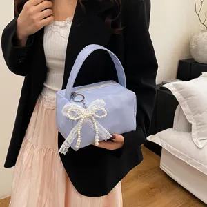 Sac de maquillage portable couleur bonbon avec élégant nœud en dentelle et perles.