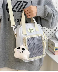 Vista detallada de un bolso cruzado japonés de lona con ventana de malla y peluche.