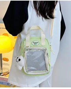 Detalle de cerca de bolso ita verde claro con bolsillo de malla transparente y peluche.