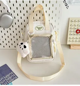 Bolso cruzado de lona estilo japonés ita bag con bolsillo de malla y colgante de peluche.