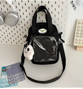 Vista detallada del bolso ita negro de lona con bolsillo transparente y lindo peluche.