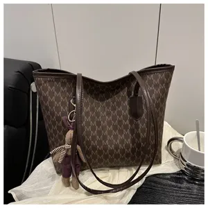 Detailed view of large capacity brown monogram tote bag with cute bunny charm pendant.