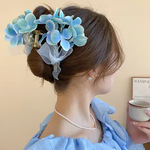 Detailed view of the blue flower hair claw clip, elegant design with white ribbon bow.