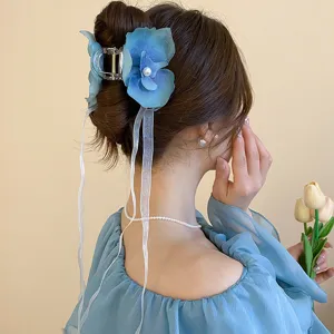 Blue floral hair claw clip with long ribbons, elegant pearl accent, detail view of a chic hair accessory.