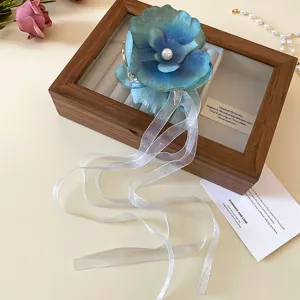 Blue floral hair claw clip with long white ribbon, elegant vacation style hair accessory for women.