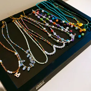 Vue détaillée de magnifiques colliers de perles de style chinois tendance avec charmants pendentifs.