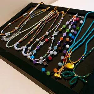 Détail de collier de perles de style chinois, perles colorées et pendentifs dorés, bijoux.