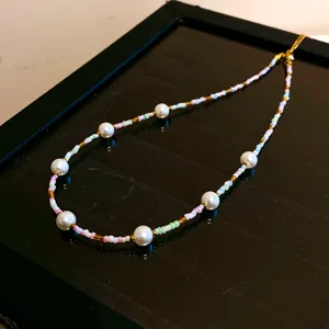 Gros plan détaillé sur le collier de perles colorées avec de fines perles de rocailles.