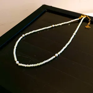Collier de perles tendance avec accents métalliques dorés pour un style élégant et chic.