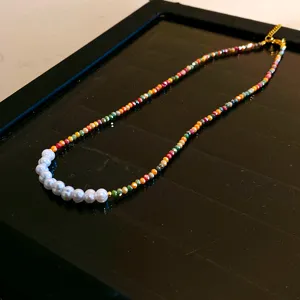 Vue détaillée du collier de perles moitié et perles colorées chaîne clavicule style doux.