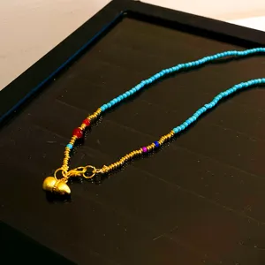 Collier de style chinois avec perles turquoise, intercalaires dorés et pendentif gourde.