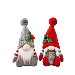 Pupazzi di peluche gnomi di Natale festivi con cappelli di maglia su sfondo bianco