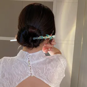 Dettaglio ravvicinato del bastoncino per capelli cinese con elegante design a foglie blu.