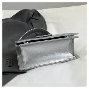 Silver metallic textured mini square shoulder bag detail showcasing exquisite clasp and compact style.