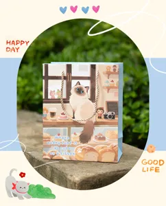 Détail du sac cadeau illustré de chat mignon avec une poignée en papier solide et élégante.