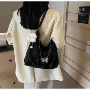 Detail view of casual soft dumpling shoulder bag featuring metal butterfly and cute cloud pendant.