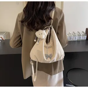 Detail view of stylish soft slouchy women backpack with metallic butterfly and cloud charm.