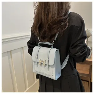 Casual women's light blue backpack detail showing trendy bow decoration and shoulder strap design.