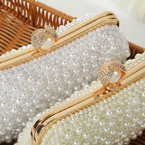 Elegant pearl beaded evening clutch bag with gold-tone rhinestone clasp detail for women.