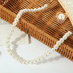 Pearl beaded evening bag detail featuring elegant faux pearls and wicker tray background scene.