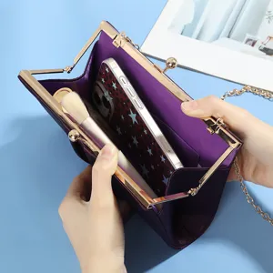 Gros plan détaillé de la capacité intérieure et du fermoir doré de la pochette en satin.
