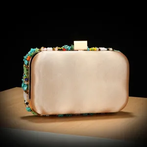 Detailed view of luxury beaded evening clutch bag with colorful stones and gold satin finish.