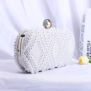 White pearl clutch bag detail showing exquisite beadwork and metallic frame design.