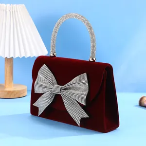 Elegant red velvet evening bag with sparkling rhinestone bow and handle for women parties.