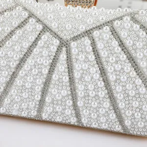 Detailed view of luxury pearl evening clutch bag with sparkling rhinestone geometric patterns.