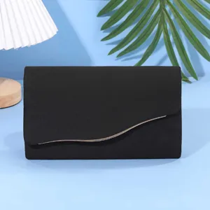 Dettaglio clutch da sera in camoscio nero con elegante finitura metallica e morbida texture.