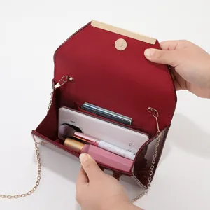 Burgundy leather evening clutch bag with chain strap and practical interior card slots.