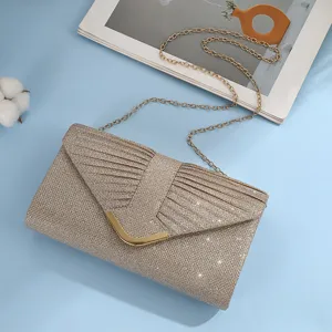 Dettaglio pochette da sera glitterata dorata, tracolla a catena e chiusura metallica.