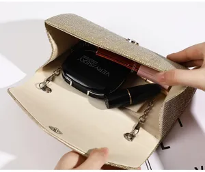 Primo piano sui dettagli dell'interno e della capienza della pochette da sera plissata dorata.