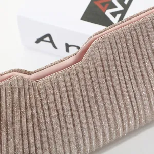 Close-up detail of the sparkling pleated evening clutch bag, showing exquisite texture and pink lining.