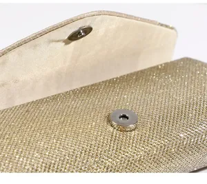 Dettaglio borsa da sera glitterata oro con chiusura magnetica metallica e consistenza.