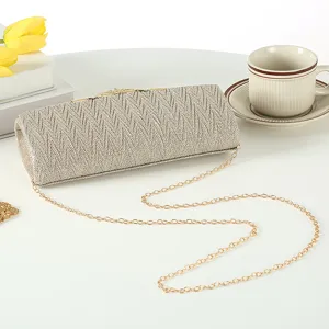 Details view of a sparkling gold evening clutch bag with chain strap for luxury events and parties.